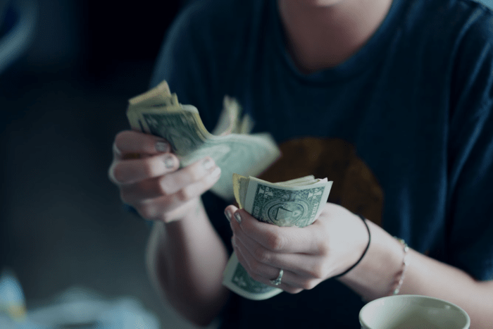 Woman counting dollars in cash.