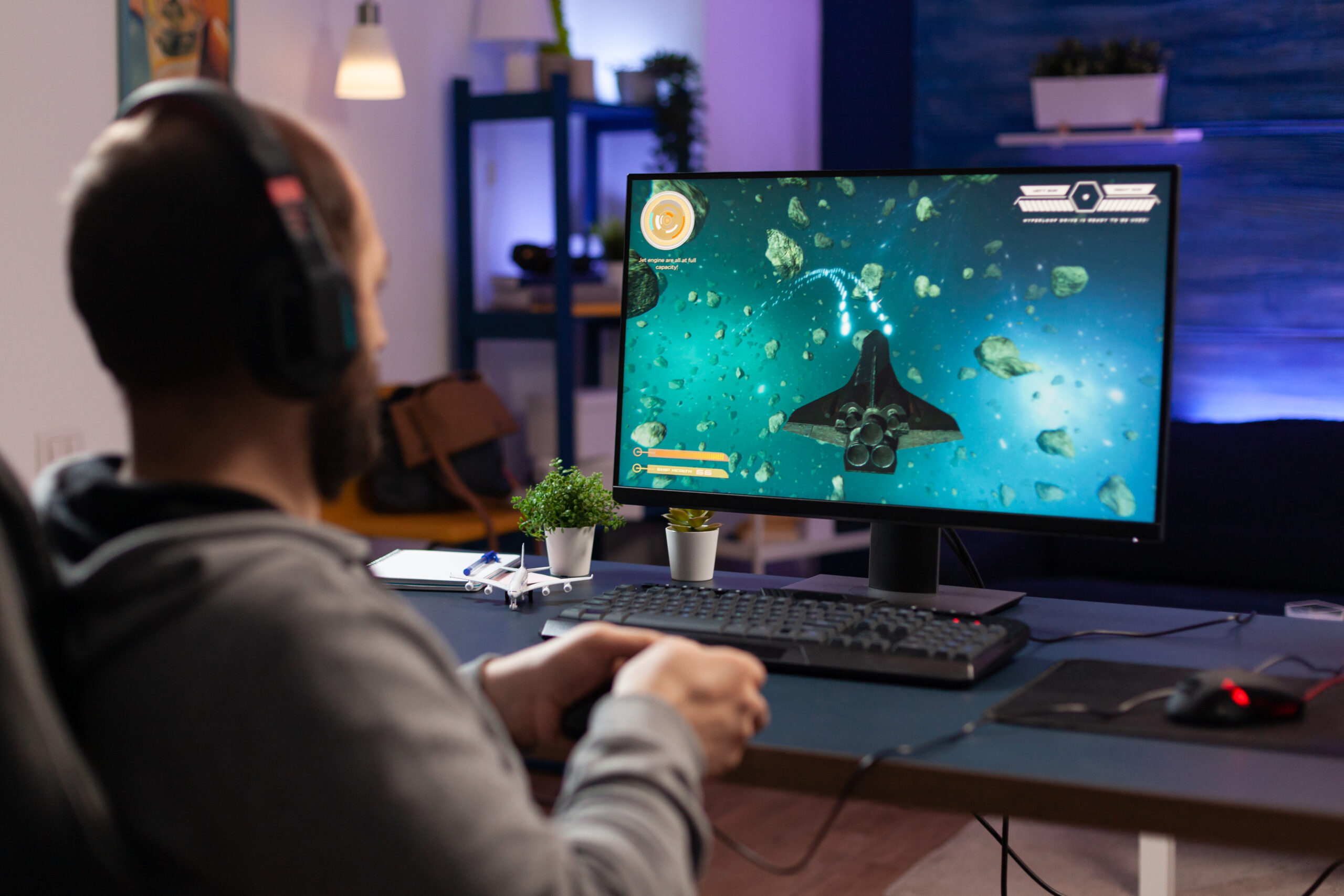 A gamer playing a space-themed RNG game on his PC.
